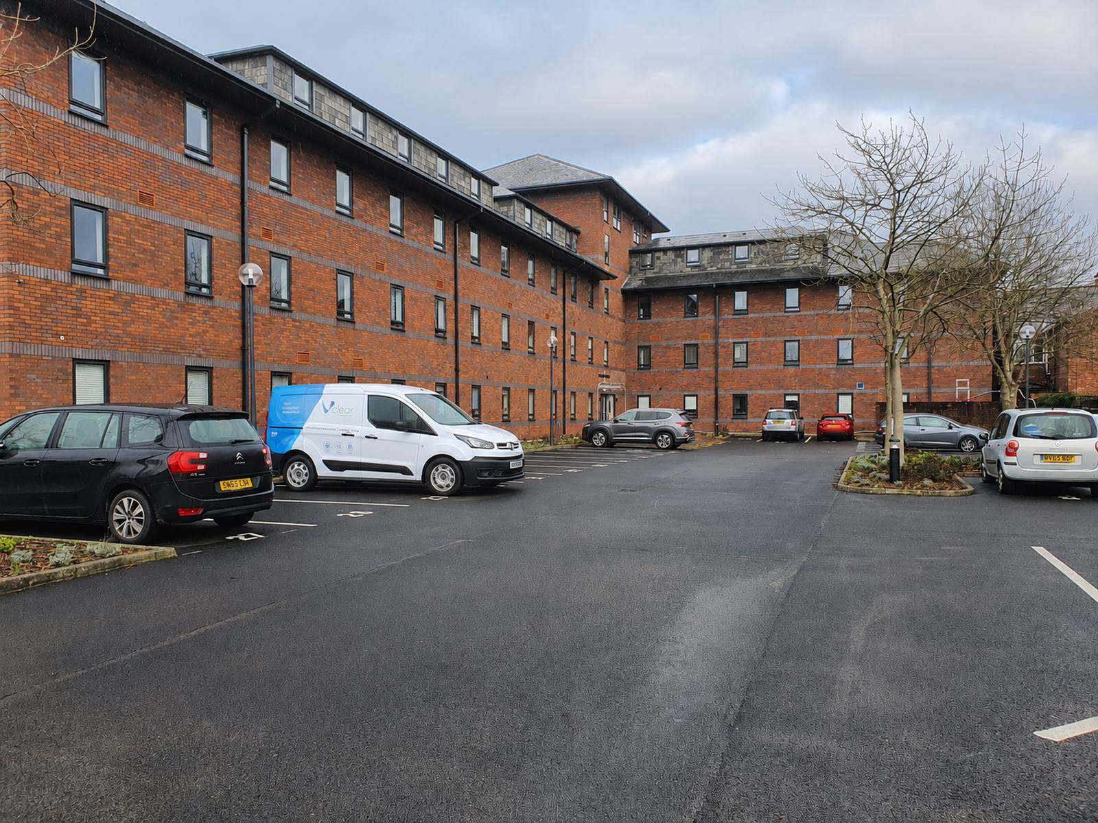Apartment block exterior with clean communal parking area